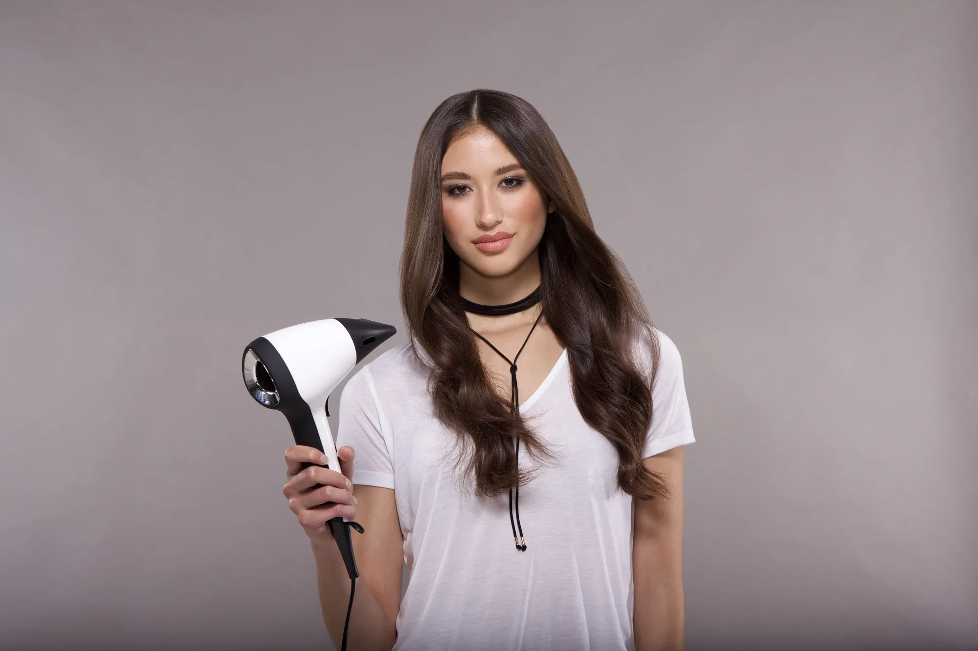 Brünette Frau mit weißem Haartrockner